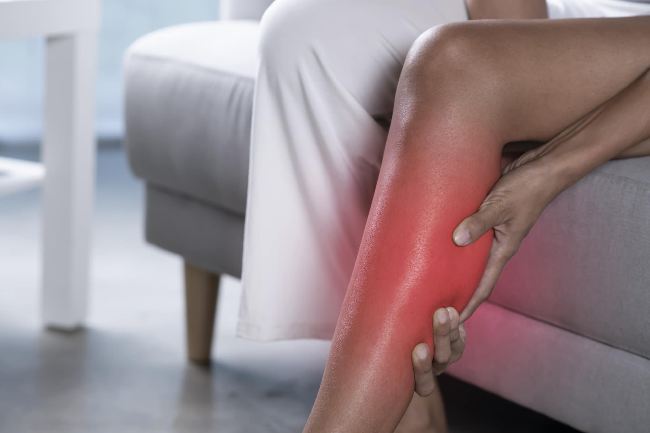 Woman holding the calf with pain. Woman holding the calf with pain. Close-up image of female suffering from pain in leg at home. Health care concept.